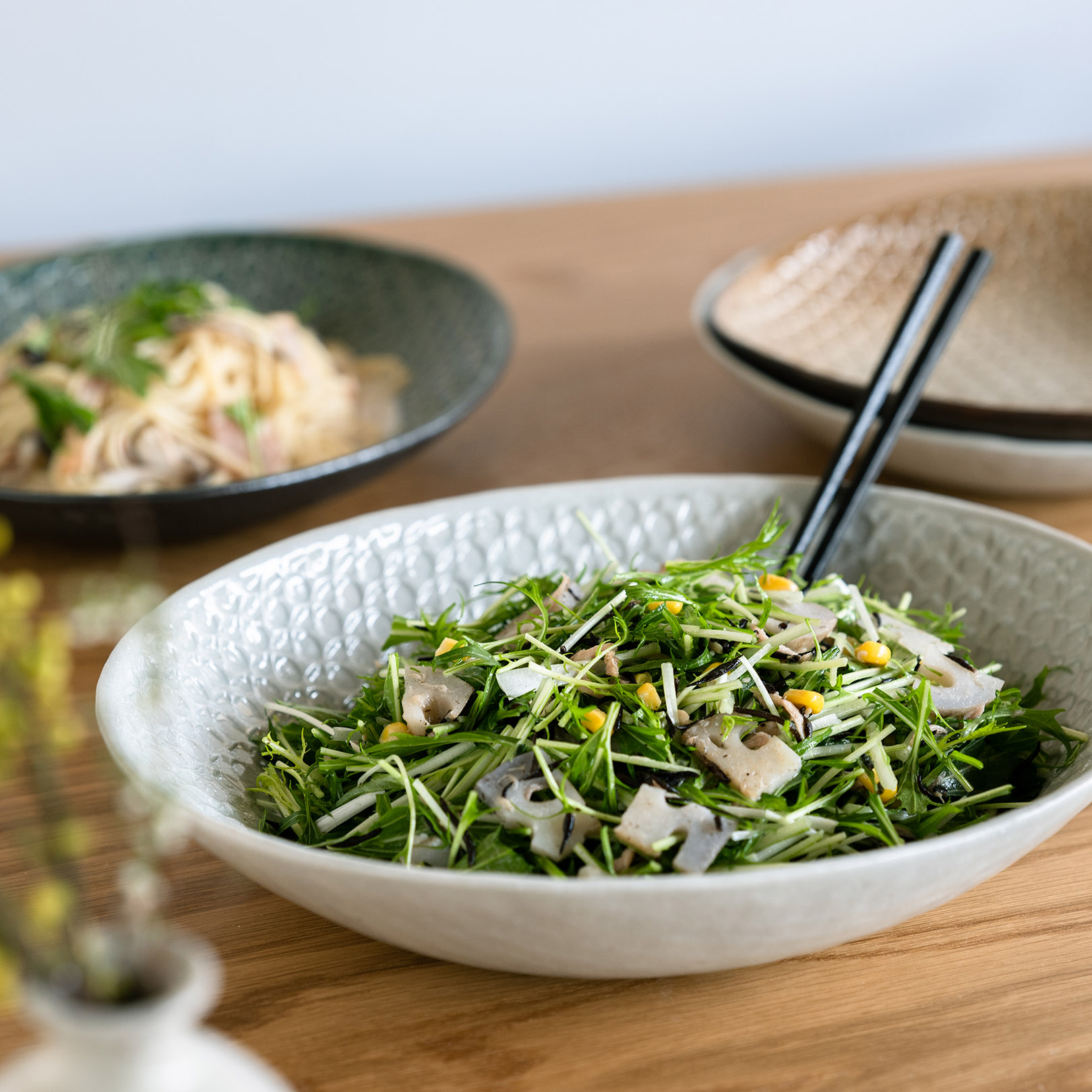 白い信楽焼の大皿に盛り付けられたサラダ。フレッシュな野菜が映えるデザイン